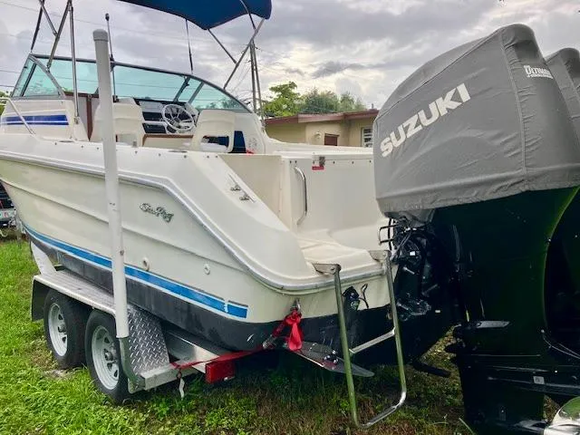 Slide: The Image of 1990 Sea Ray 240 Sundeck boat on trailer with Suzuki outboard motor. - 2