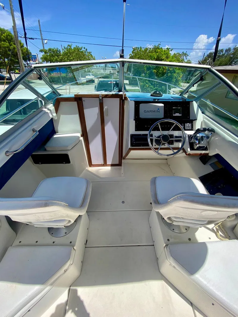 Slide: The Image of 1990 Sea Ray 240 Sundeck boat interior with dual seats and steering wheel. - 24