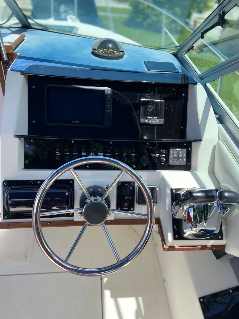 Slide: The Image of Steering console of 1990 Sea Ray 240 Sundeck with modern controls and navigation equipment. - 25