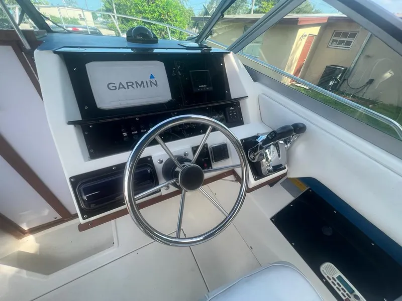 Slide: The Image of 1990 Sea Ray 240 Sundeck helm with Garmin navigation system and steering wheel. - 26