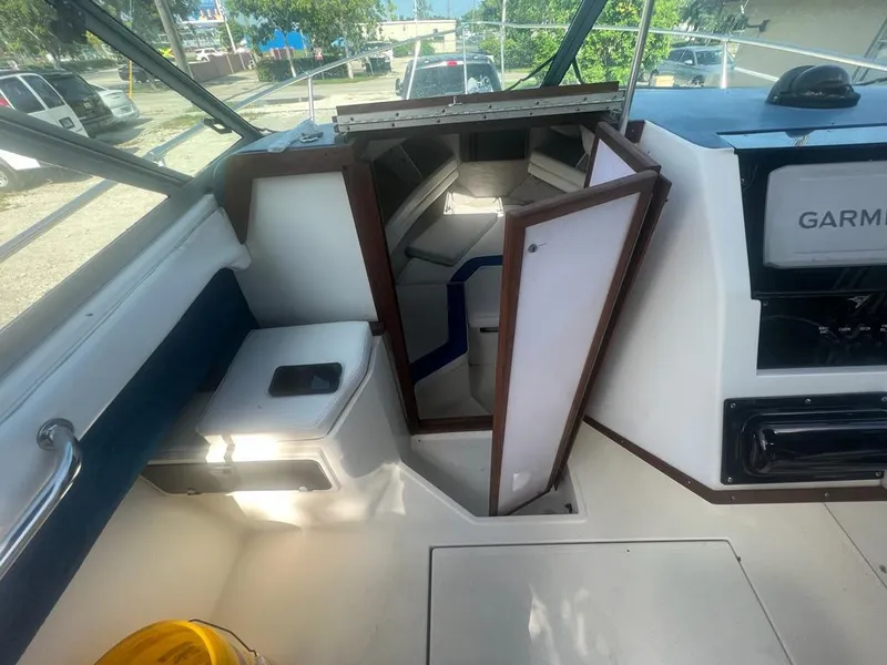 Slide: The Image of Interior of 1990 Sea Ray 240 Sundeck boat with open cabin door and seating. - 29