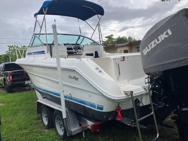 Slide: The Image of 1990 Sea Ray 240 Sundeck boat on trailer with Suzuki outboard motor. - 3