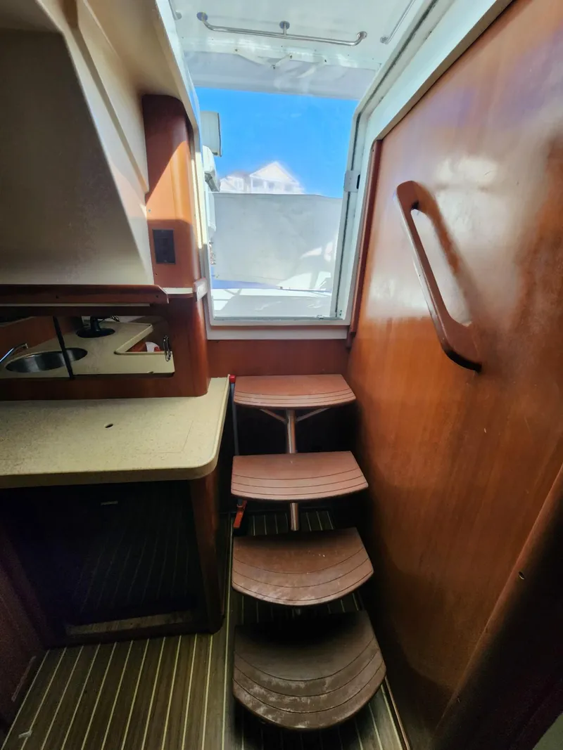 Slide: The Image of Interior view of 2004 Luhrs 36 Open boat with wooden steps and compact kitchenette. - 29