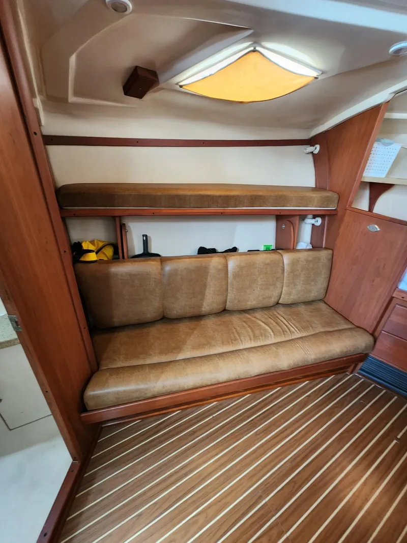 Slide: The Image of 2004 Luhrs 36 Open cabin interior with wooden flooring and cushioned seating. - 30