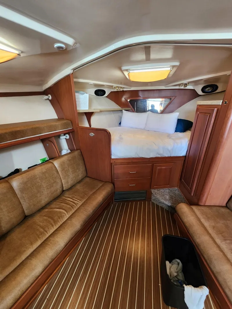 Slide: The Image of 2004 Luhrs 36 Open cabin interior with bed, seating, and wooden finishes. - 32