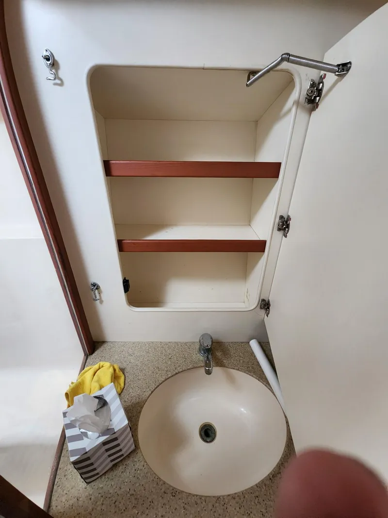 Slide: The Image of 2004 Luhrs 36 Open boat bathroom sink with open cabinet and shelves. - 42