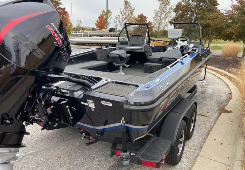 Slide: The Image of 2024 Nitro ZV20 fishing boat with powerful outboard motor, parked on a trailer. - 3