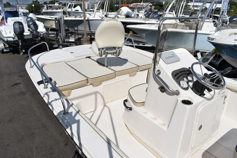Slide: The Image of 2021 Carolina Skiff 19 LS boat with seating and console, docked among other boats. - 18