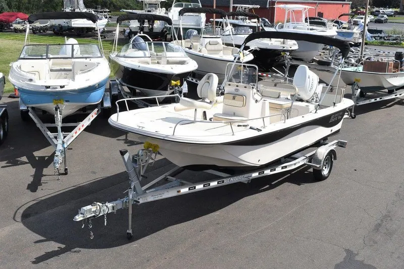 Slide: The Image of 2021 Carolina Skiff 19 LS boat on trailer, surrounded by other boats in a lot. - 2