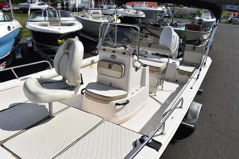 Slide: The Image of 2021 Carolina Skiff 19 LS boat with seating and console, displayed in a marina. - 20