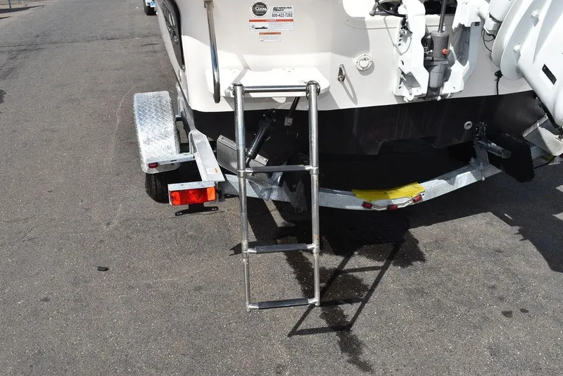 Slide: The Image of 2021 Carolina Skiff 19 LS boat with rear ladder and trailer on asphalt. - 22