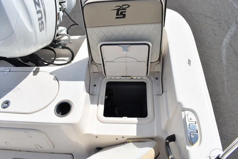 Slide: The Image of 2021 Carolina Skiff 19 LS boat storage compartment and Suzuki engine detail. - 24