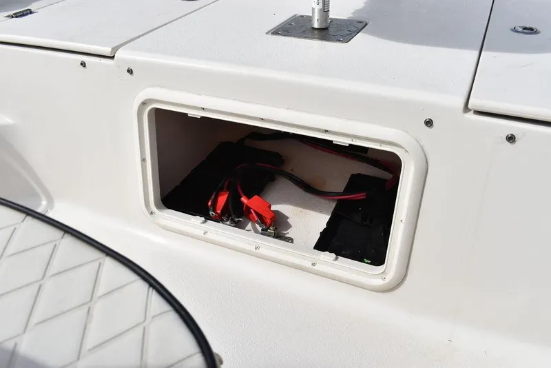 Slide: The Image of Battery compartment of 2021 Carolina Skiff 19 LS boat with red and black cables. - 47