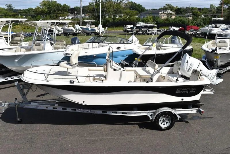 Slide: The Image of 2021 Carolina Skiff 19 LS boat on trailer, displayed in a marina. - 5
