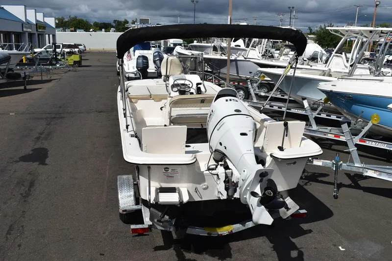 Slide: The Image of 2021 Carolina Skiff 19 LS boat with outboard motor and canopy in a marina. - 8