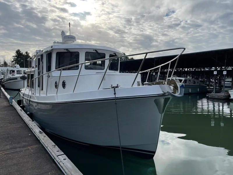 Slide: The Image of 2025 American Tug 362 docked at a marina under a cloudy sky. - 16