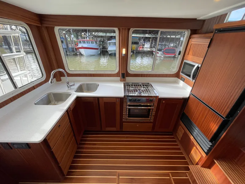 Slide: The Image of Modern kitchen in 2025 American Tug 362 boat with wood cabinetry and large windows. - 18