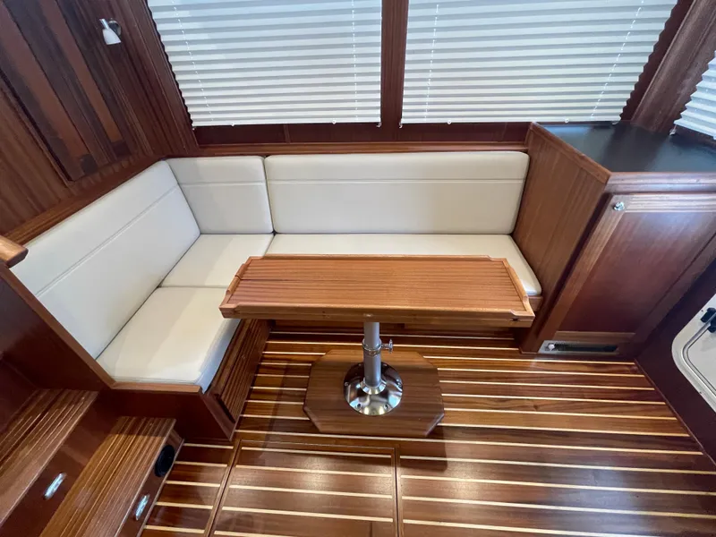 Slide: The Image of 2025 American Tug 362 interior with wood finish and white cushioned seating. - 19