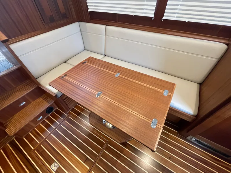 Slide: The Image of 2025 American Tug 362 interior with wooden table and cushioned seating. - 20