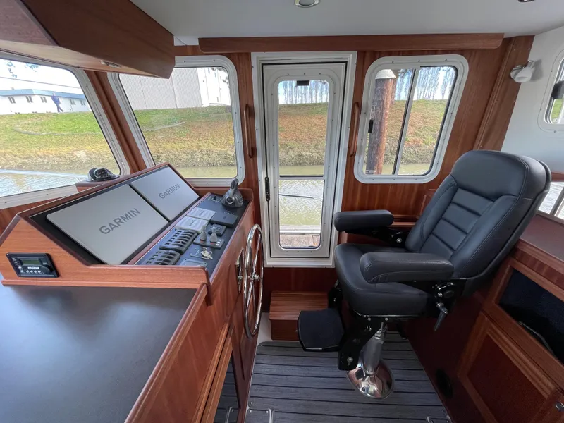 Slide: The Image of American Tug 362 2025 model helm station with Garmin navigation system and captain's chair. - 25