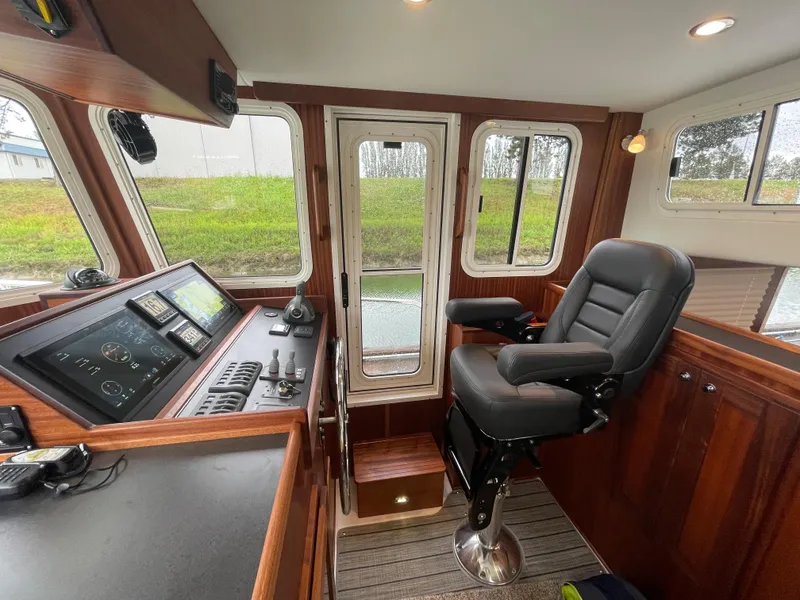 Slide: The Image of 2025 American Tug 362 helm station with captain's chair and navigation controls. - 27