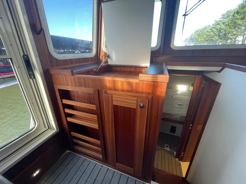 Slide: The Image of Interior of 2025 American Tug 362 with wooden cabinetry and stairs to lower deck. - 29