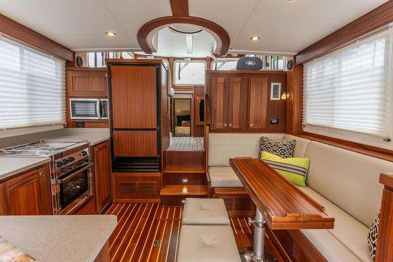 Slide: The Image of Interior of 2026 American Tug 362, featuring wood finishes, dining area, and modern kitchen appliances. - 5