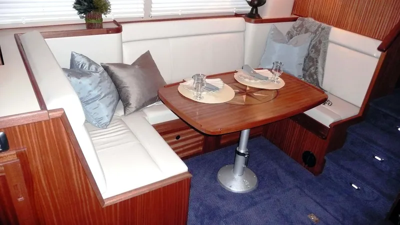 Slide: The Image of Elegant dining area in 2025 American Tug 365 with plush seating and wooden table. - 15