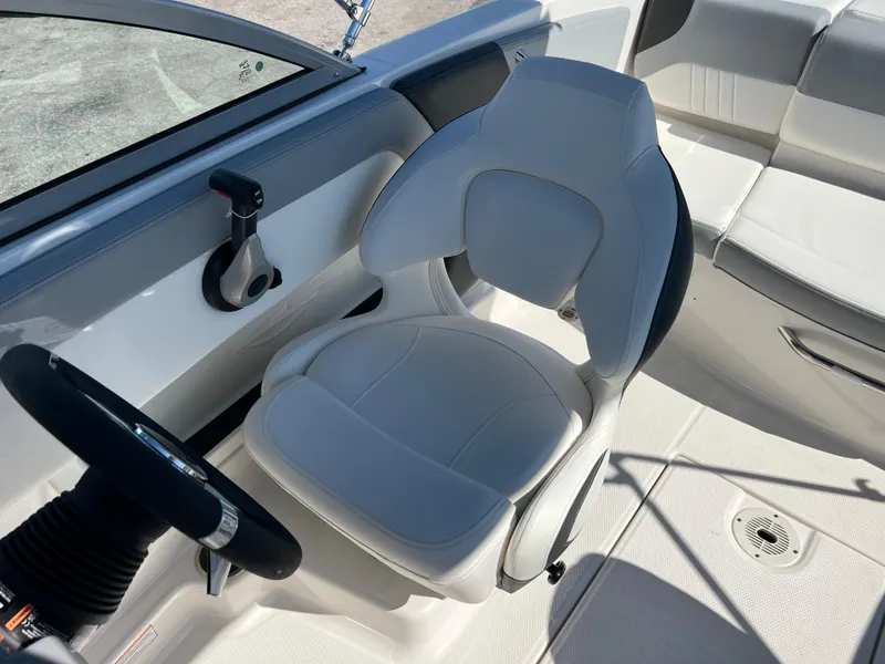 Slide: The Image of 2024 Chaparral 19 SSi boat interior with captain's chair and steering wheel. - 11
