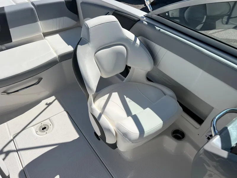 Slide: The Image of 2024 Chaparral 19 SSi boat interior with white seating and steering area. - 12