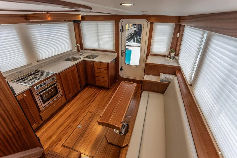 Slide: The Image of 2026 American Tug 395 interior with wood finish, kitchen, and seating area. - 11