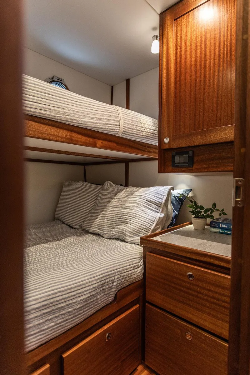 Slide: The Image of Cozy cabin interior of 2026 American Tug 395 with wooden furnishings and bunk beds. - 14