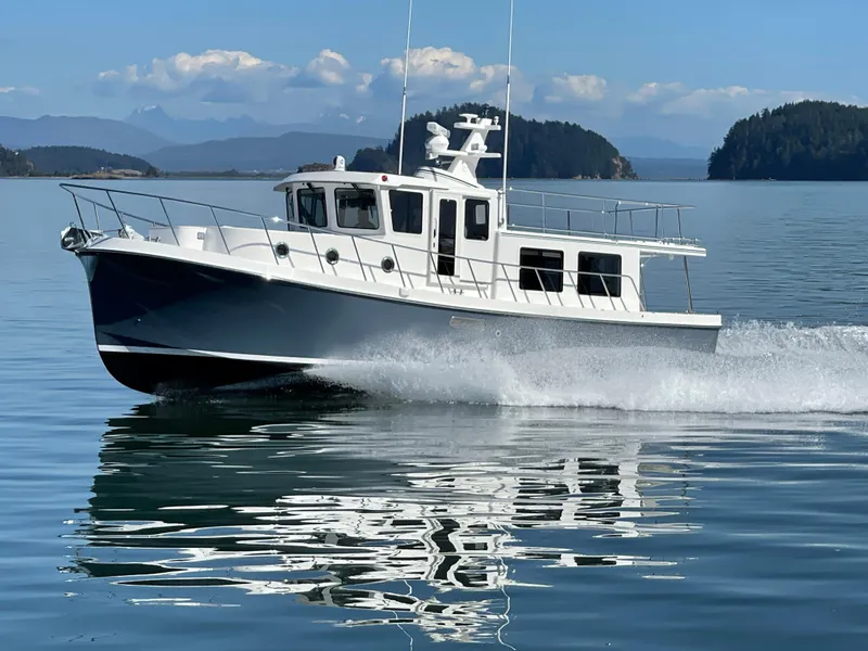 Slide: The Image of 2025 American Tug 395 cruising on a serene lake with mountainous backdrop. - 18