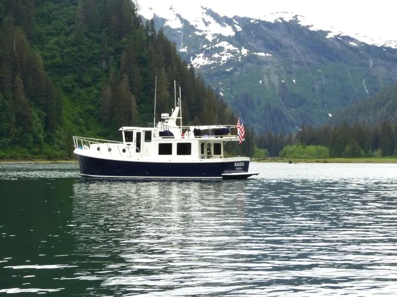 Slide: The Image of American Tug 395 (2025) cruising in a scenic mountain lake. - 19