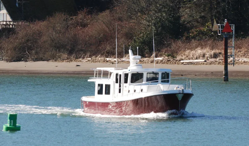 Slide: The Image of 2025 American Tug 395 cruising on a calm river near the shore. - 23