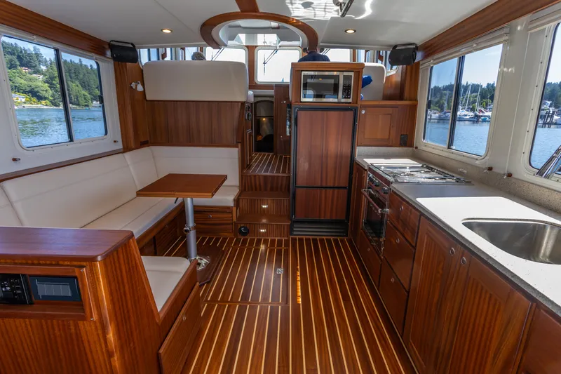Slide: The Image of Interior of 2026 American Tug 395, featuring wood finishes and modern kitchen amenities. - 9