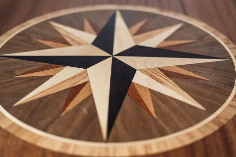 Slide: The Image of Wooden compass rose design on American Tug 435, 2026 model. - 18