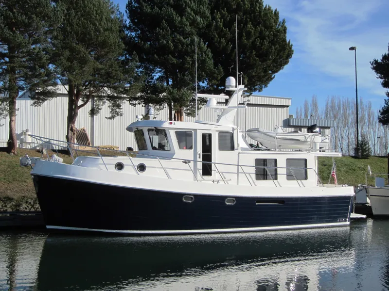 Slide: The Image of 2025 American Tug 435 model docked in a serene marina. - 26