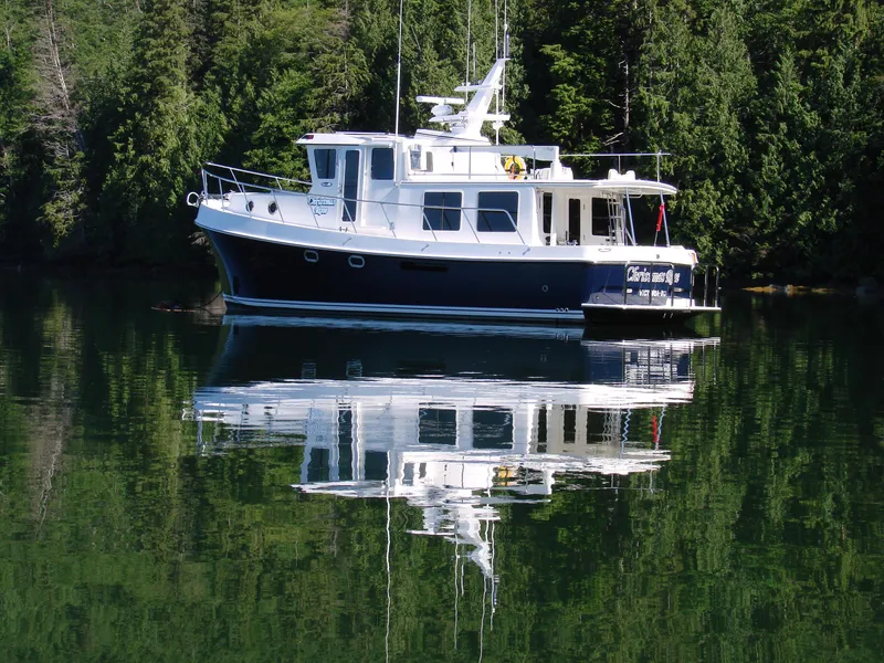 Slide: The Image of 2025 American Tug 435 boat reflected on calm water with forest background. - 29