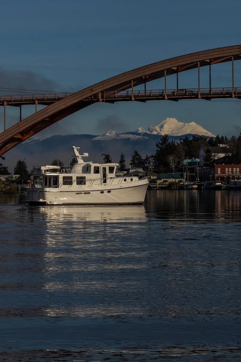 Slide: The Image of 2026 American Tug 435 cruising under a bridge with mountain backdrop. - 5