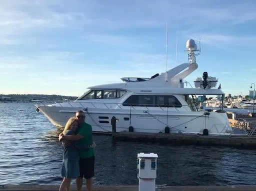 Slide: The Image of Couple posing in front of 2007 Regency Yachts 670 Pilothouse at marina. - 2