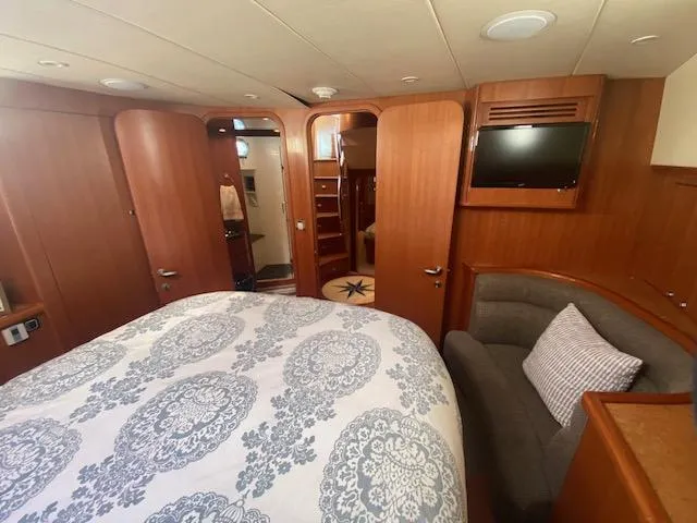 Slide: The Image of Luxurious bedroom in 2007 Regency Yachts 670 Pilothouse with wood paneling and TV. - 32