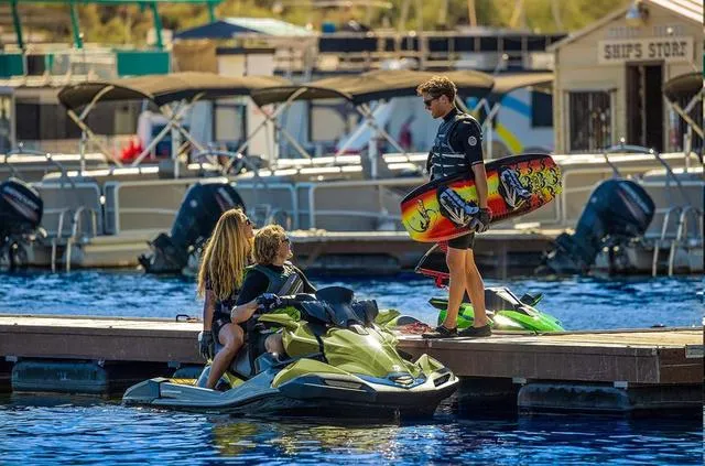 Slide: The Image of People enjoying a 2024 Kawasaki Waverunner JET SKI® ULTRA® 310LX at a marina. - 3