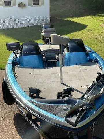 Slide: The Image of 2006 Nitro 901 CDX DC fishing boat with dual motors and seating, parked on grass. - 2
