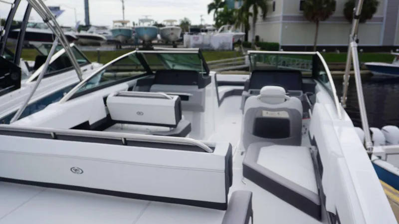 Slide: The Image of 2024 Cobalt R4 boat interior with white and gray seating, docked at marina. - 12