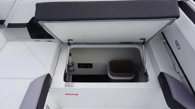 Slide: The Image of Open storage compartment in 2024 Cobalt R4 boat with fire extinguisher and bin. - 8