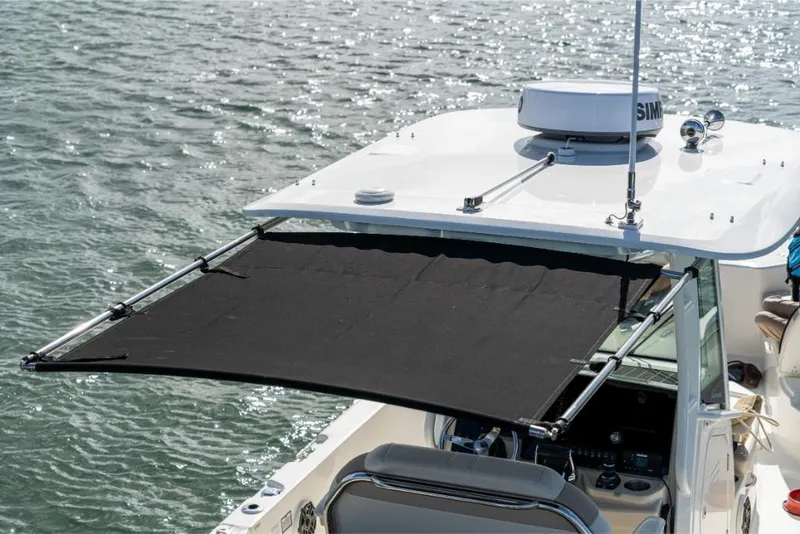 Slide: The Image of 2024 Boston Whaler 280 Dauntless boat with extended sunshade on water. - 13