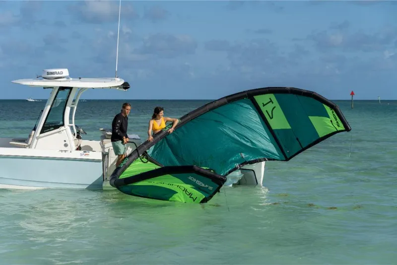 Slide: The Image of 2024 Boston Whaler 280 Dauntless with people preparing a kiteboard in shallow water. - 17