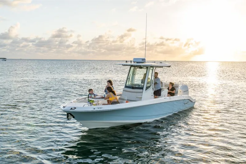 Slide: The Image of 2024 Boston Whaler 280 Dauntless boat on water at sunset with people onboard. - 2