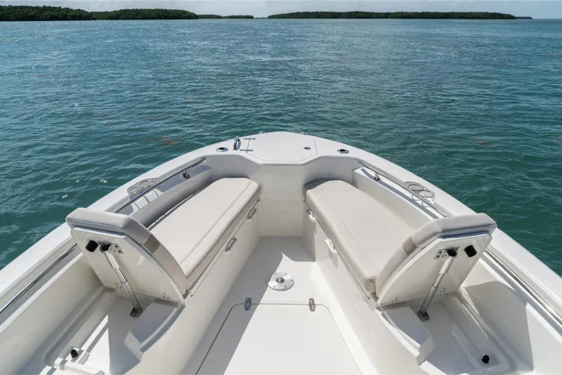 Slide: The Image of 2024 Boston Whaler 280 Dauntless boat interior with cushioned seating on calm water. - 38